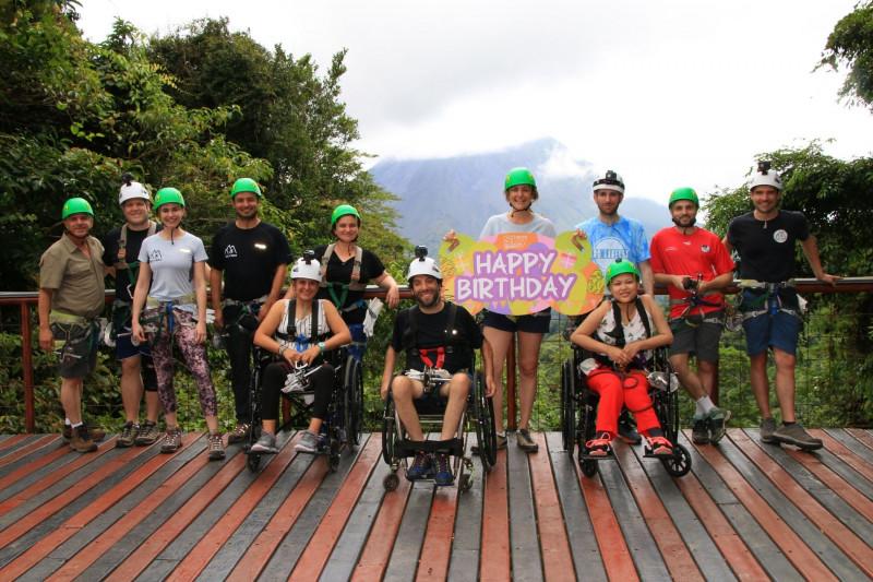 A group of travelers, including two wheelchair users, pose for a picture in Costa Rica
