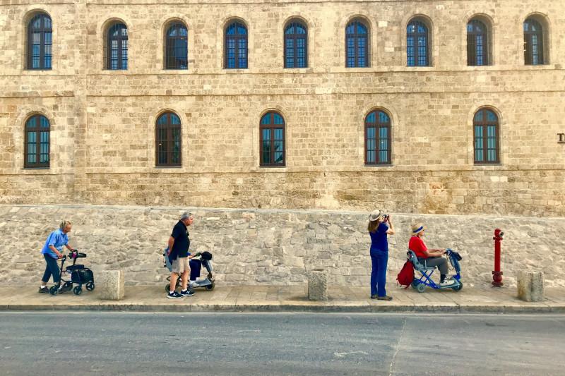 The tour group explores Israel, with several members using mobility aids.
