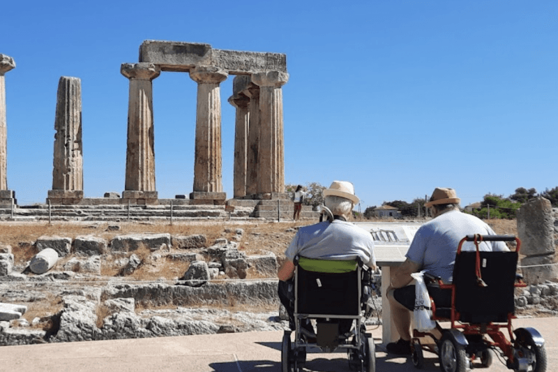 Two tourists in wheelchairs visit a historic landmark.