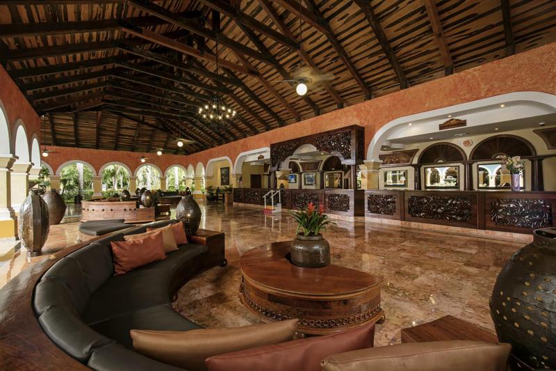 Lobby Iberostar Paraiso Beach with smooth marble floors, vaulted ceilings, and detailed standing height front desk