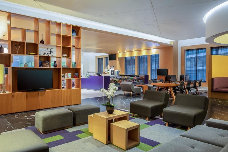 Lobby with comfortable seating areas, a television, business lounge area, and a snack bar