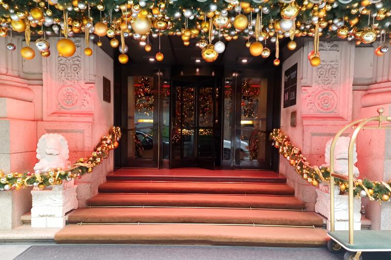Hotel entrance with revolving door, lion statues and steps