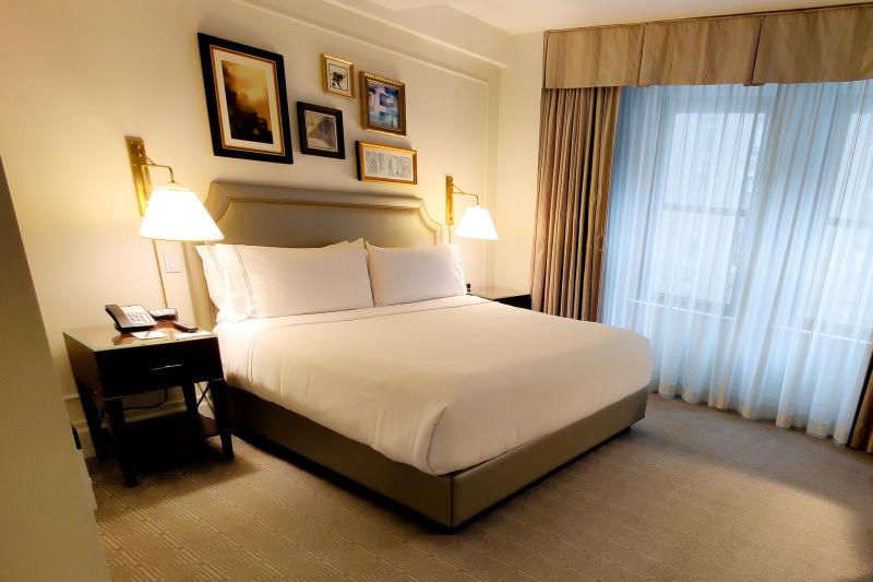 The accessible room, with a king-sized bed, carpeted floor, bedside tables and large windows.