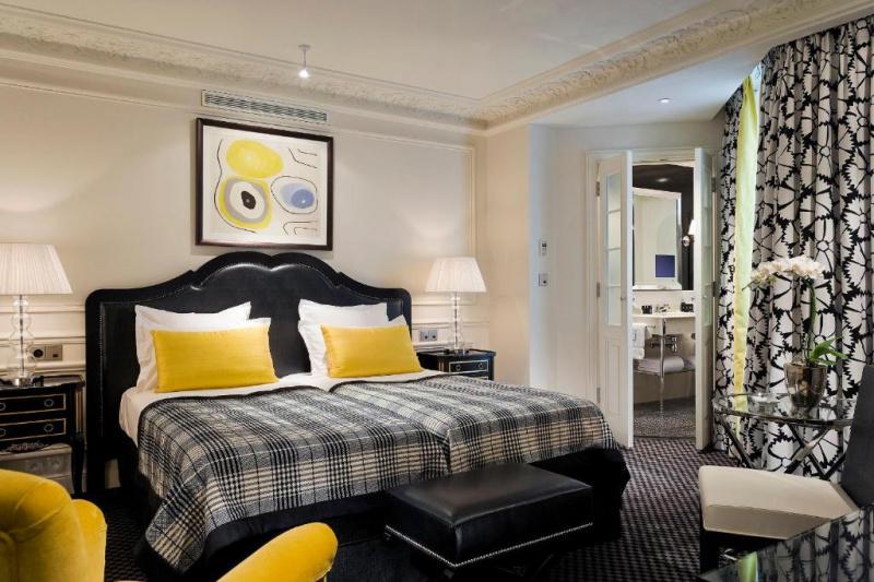 An accessible guest room with a double bed, a carpeted floor, bedside tables and an ensuite bathroom.