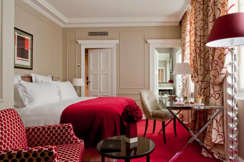 The accessible guest room, with a carpeted floor, a king-sized bed, and a seating area with an armchair.