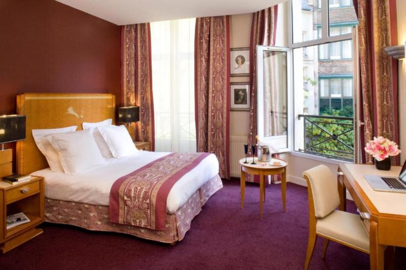 A guest room at the hotel with a double bed and a carpeted floor