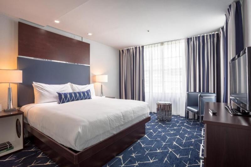 The deluxe king room has a king-size bed, an armchair and a large TV.