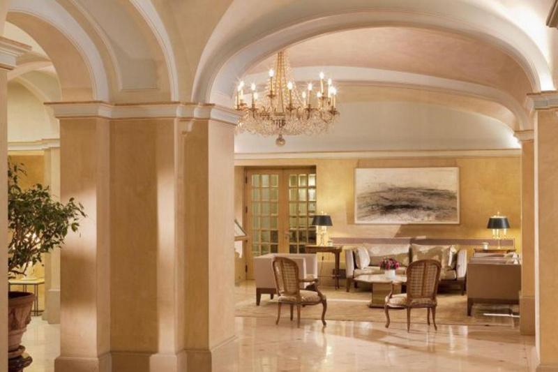 The hotel lobby has comfortable sofas and armchairs, chandeliers and artwork on the walls.