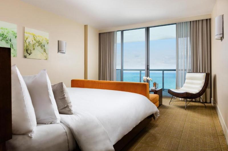 Junior suite ocean view has a king-sized bed, a comfortable seating area with sofa and chair and a balcony with ocean views.