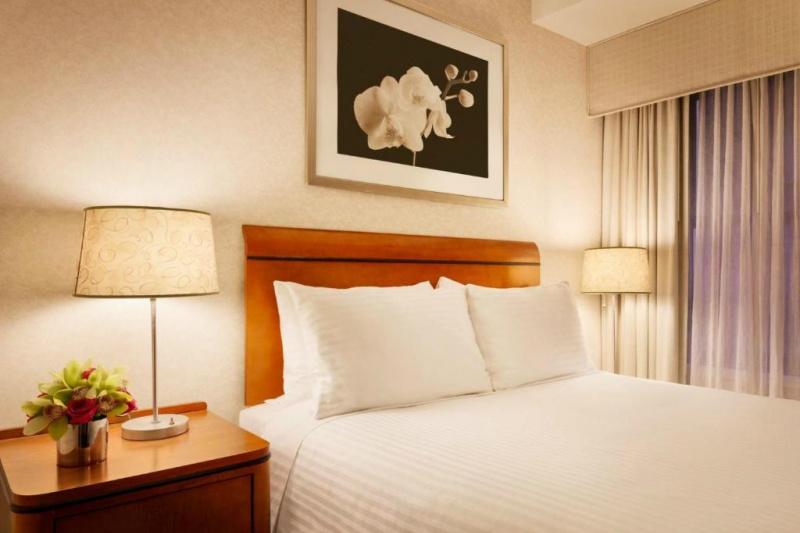 The Junior suite has a queen-sized bed, bedside console with a lamp and artwork on the wall.