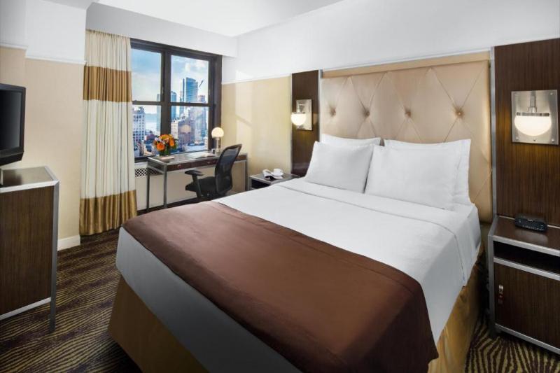 The metro queen room has a queen-sized bed, a desk and chair and a TV.