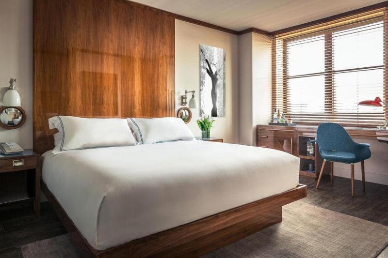 The superior king room has a king-size bed with white linen, bedside tables with a telephone, reading lamps and a chair. There is a desk under a window at the far end of the room. The desk has drinks cabinets built in to one end.