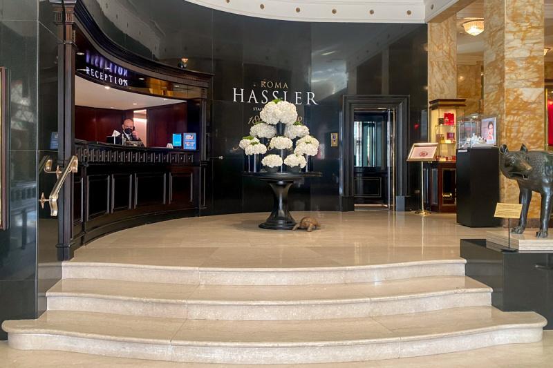 There are 4 small steps leading to the spacious reception area. There is a high reception desk and a round table with a flower arrangement.