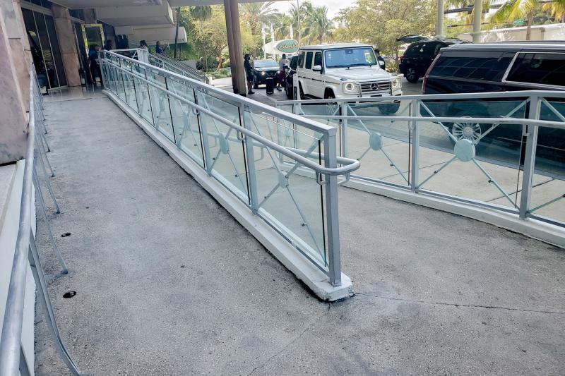 There is a long ramp with handrails leading from the drop-off zone to the hotel entrance.