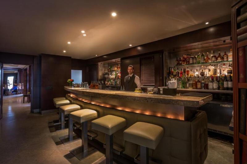 The spacious bar area has a long curved bar. There are high bar stools along the side of the bar.