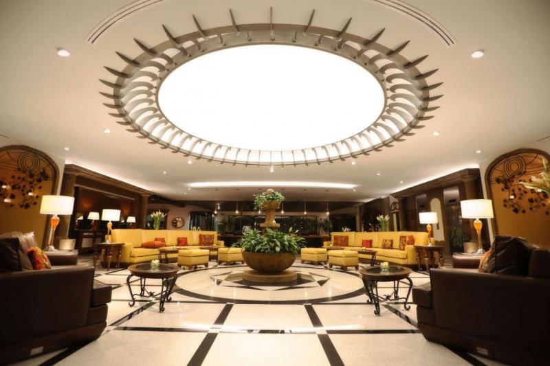 The hotel lobby is spacious and step-free. There are 2 large, curved sofas, and 2 large armchairs. Coffee tables and footstools are dotted around the room.