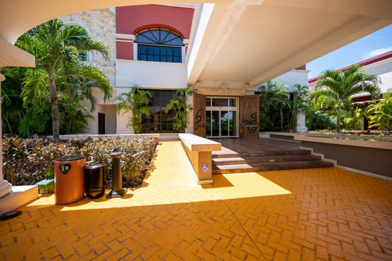 There is a ramp next to a flight of three steps leading up to the hotel entrance. Automatic double glass doors lead to the lobby.