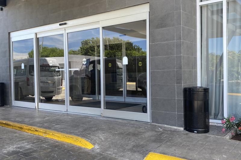 The driveway leading to the hotel entrance has a dropped curb. Access to the hotel is through 2 glass sliding doors.