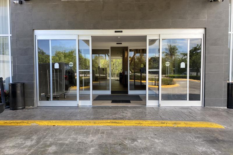 There are 2 sets of automatic doors that lead to the hotel lobby. The driveway outside has a dropped curb.