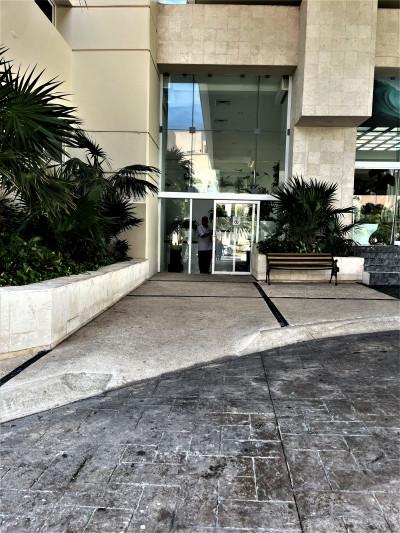 Access to the hotel is through a sliding glass door. The entrance is paved and step-free.