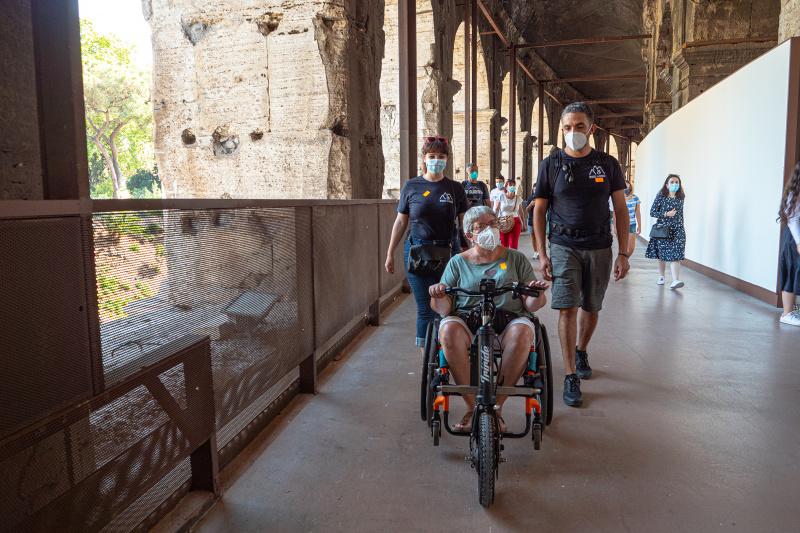 Woman on wheelchair and Wheel the World Staff view walk on smooth vinyl floor on the Colosseum property
