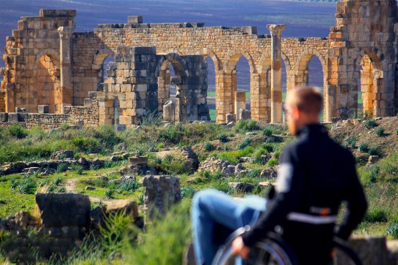 A man in a wheelchair explores Volubilis.