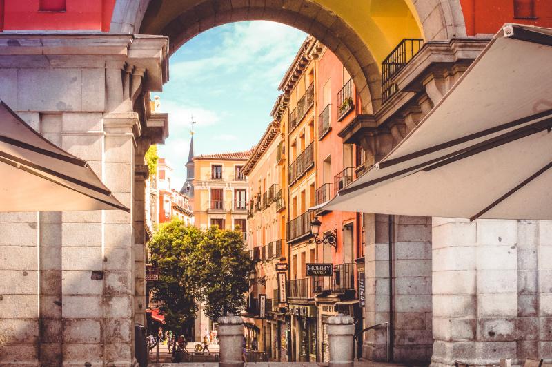 Colorful buildings seen through an arch in Madrid.