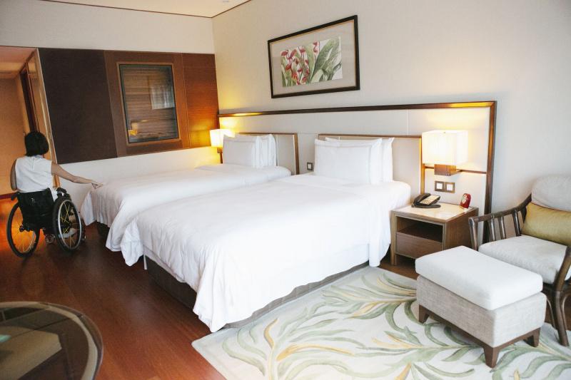 Accessible room with spacious bedside pathways and comfortable twins beds.