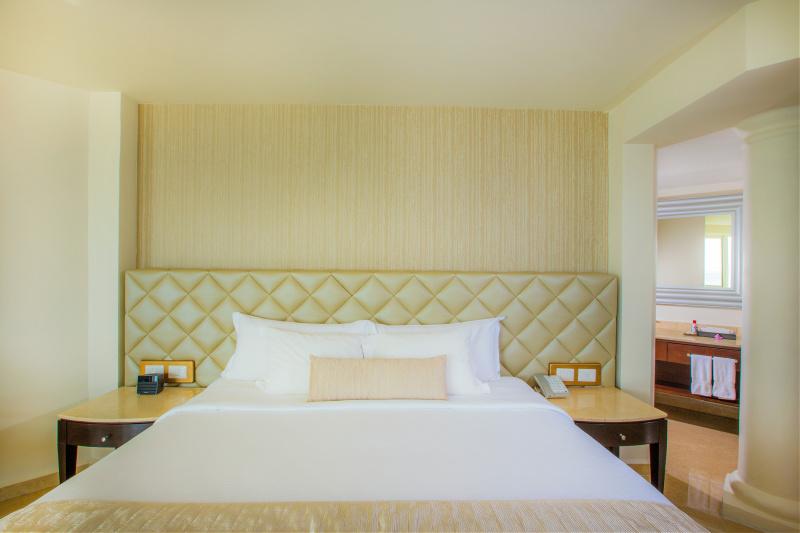 The hotel Superior Deluxe room shows a vintage creme color headboard plus two nightstands
