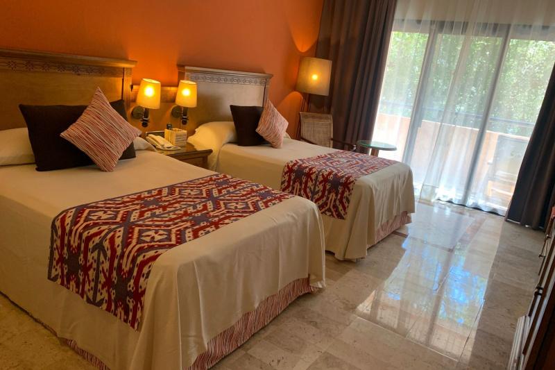 A guest room with 2 double beds and colonial-themed decor.