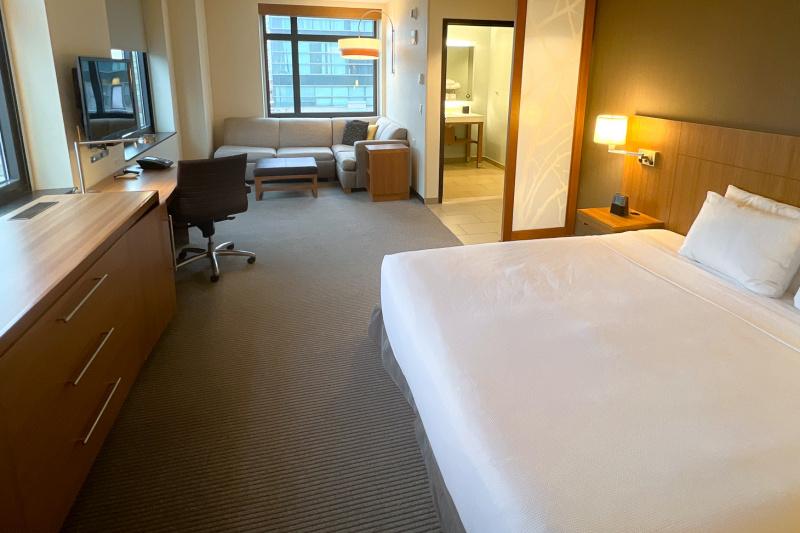 The accessible king room, with a carpeted floor, king-sized bed and an armchair.