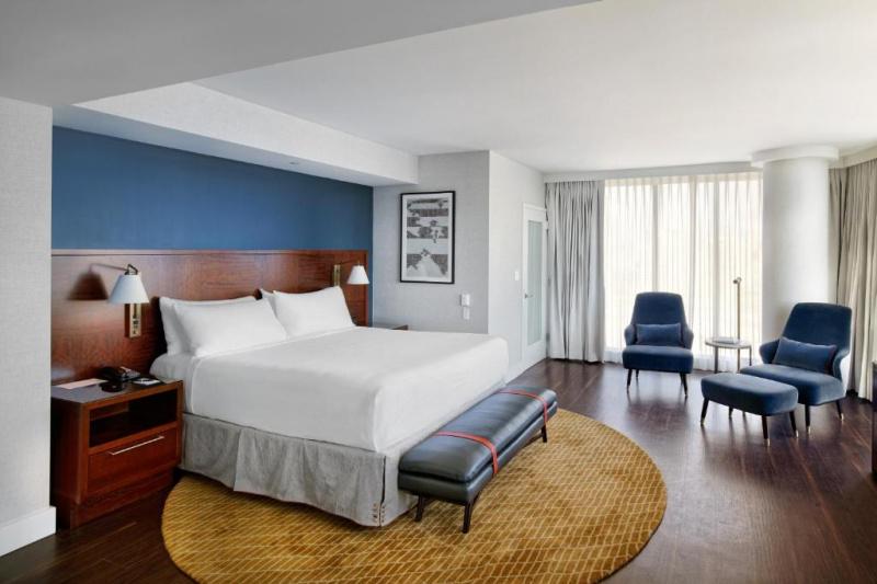An accessible room with a king-sized bed, a seating area and large windows.