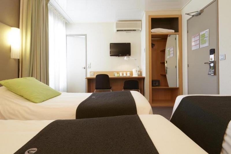 An accessible guest room with 2 single beds, a carpeted floor, a desk and a closet.