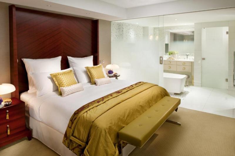 An accessible guest room with a carpeted floor, a double bed, a bedside table and an ensuite bathroom.