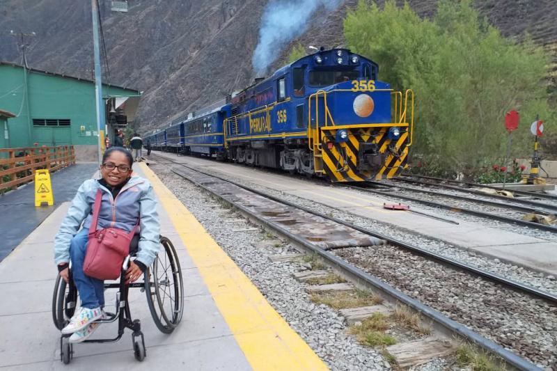 A woman in a wheel chair posing in a train station