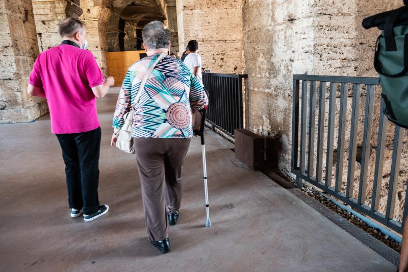 Couple using walking sticks enjoys tour of Colosseum ruins