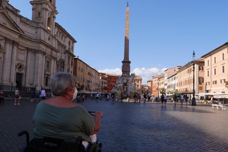 Tourist on wheelchair views the Piazza Navona tower and the astonishing baroque Sant'Agnese in Agone church