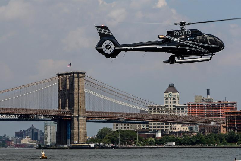 Helicopter flies around the Brooklyn Bridge.